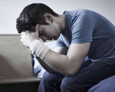 Depressed Young Man With Bandaged Wrists After Suicide Attempt